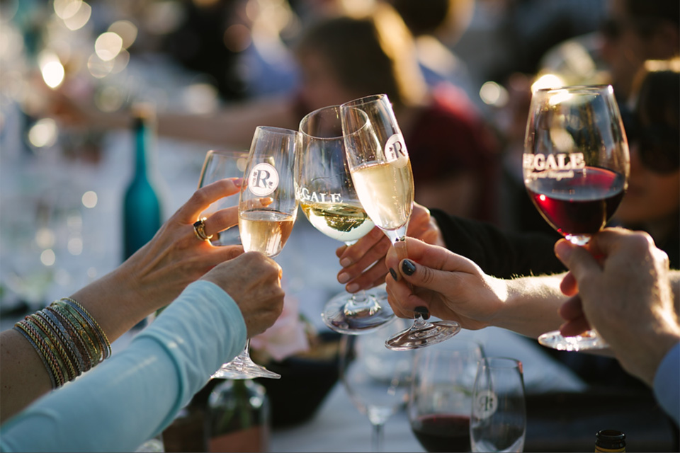 People toasting with glasses of wine at an event