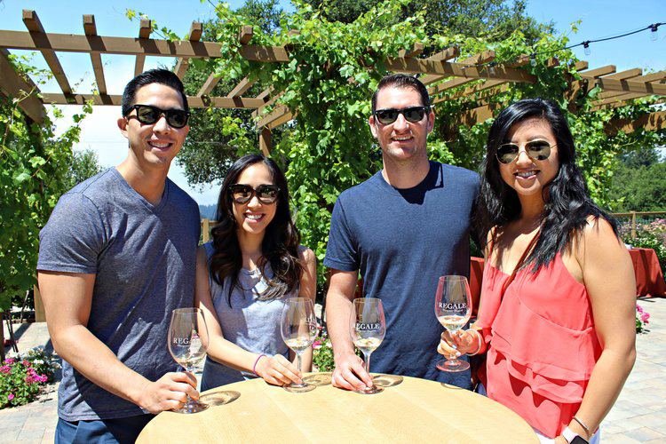 Two couples drinking wine outdoors at Regale