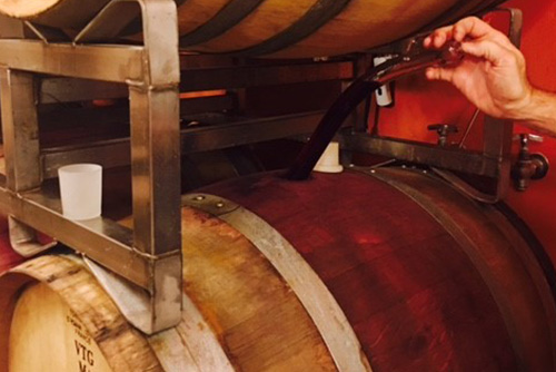 Man pouring wine from a barrel